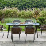 Muses Dining Set on an outdoor patio with grass and trees